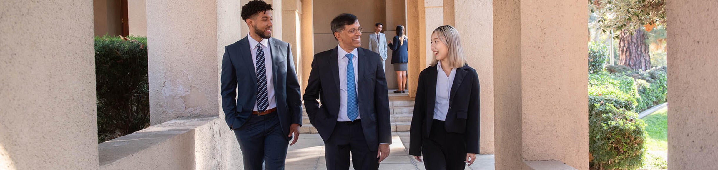 UCR School of Business professor with two graduate students